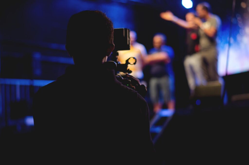 Man Standing on Stage Holding Microphone